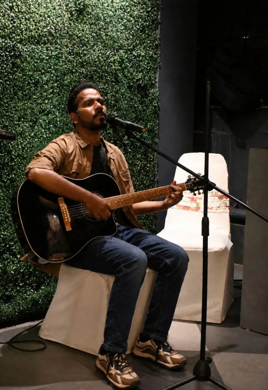Sanket Survase performing live with his acoustic guitar