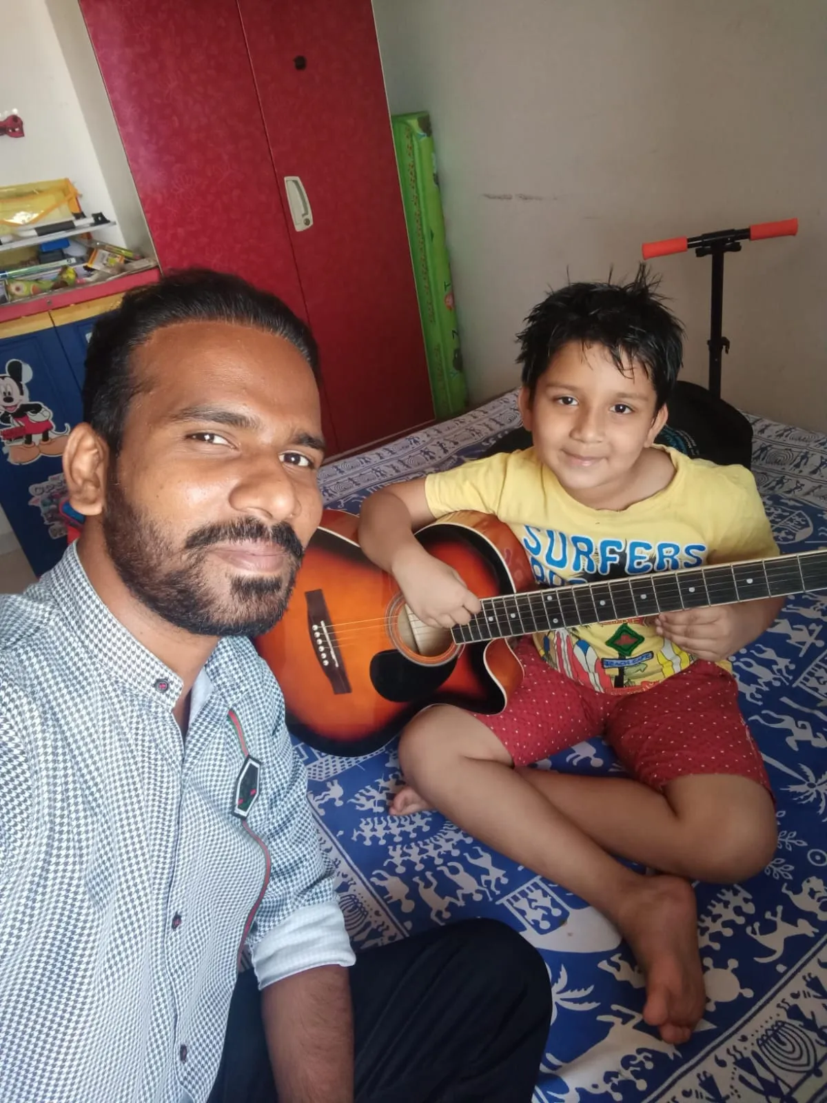 A young beginner during a home guitar lesson