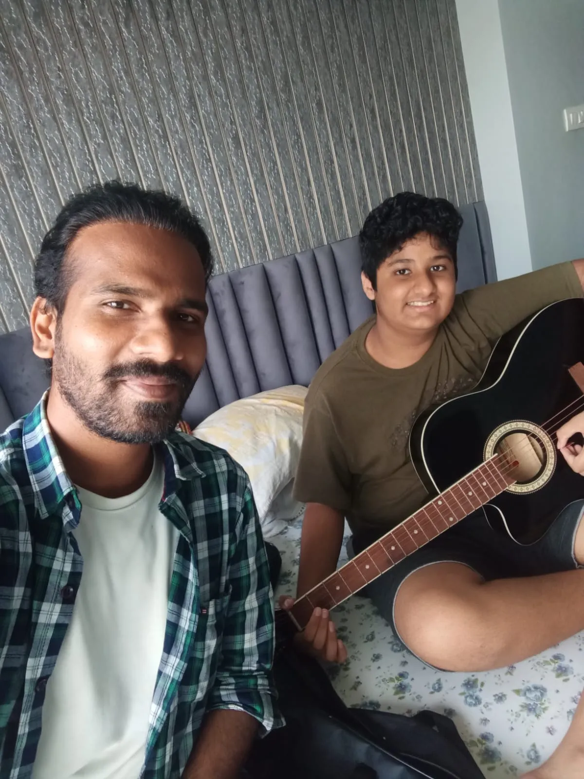 A teenager learning guitar at home